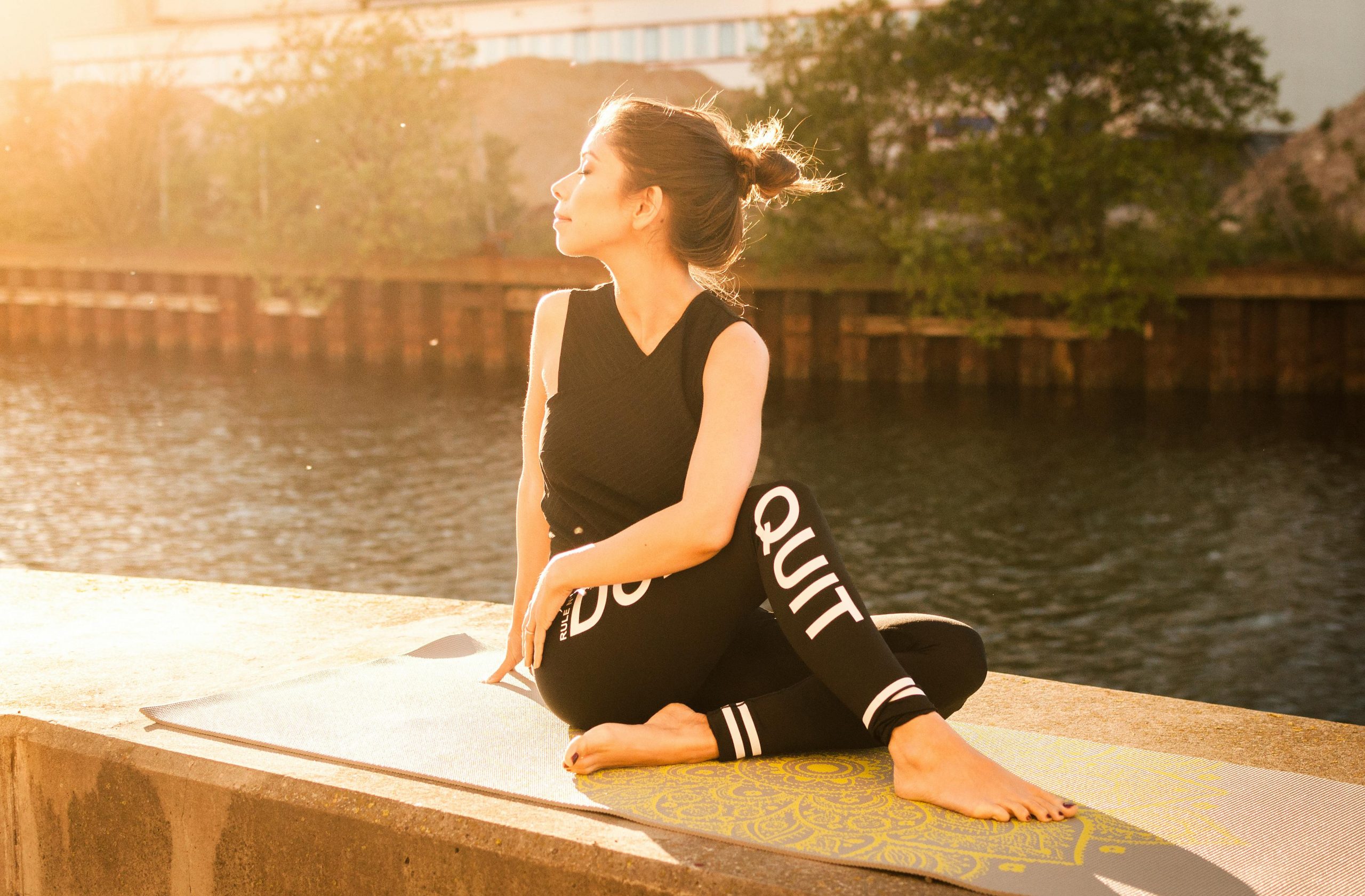 Woman practicing yoga at sunset by a serene river in Gamla Staden, Sweden. Recuperación de peso postparto con Nútrete Sano y Bonito, dietista nutricionista online experto en salud femenina